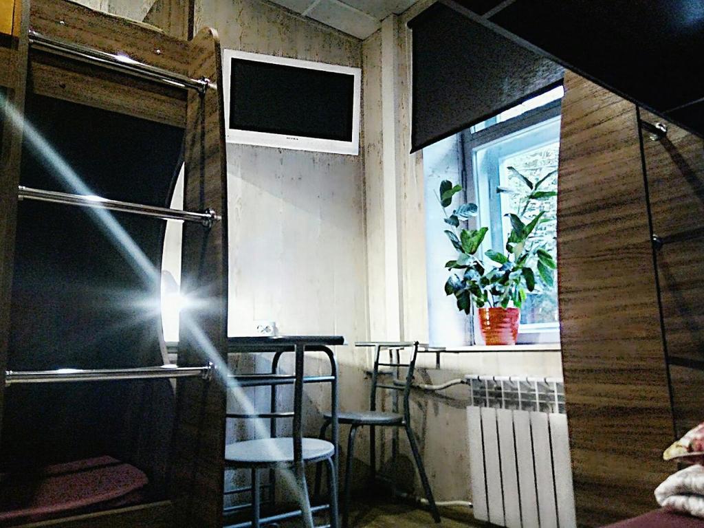 エカテリンブルクにあるホステル ウユトノイ ミステチカのバー(椅子2脚付)と窓が備わる客室です。