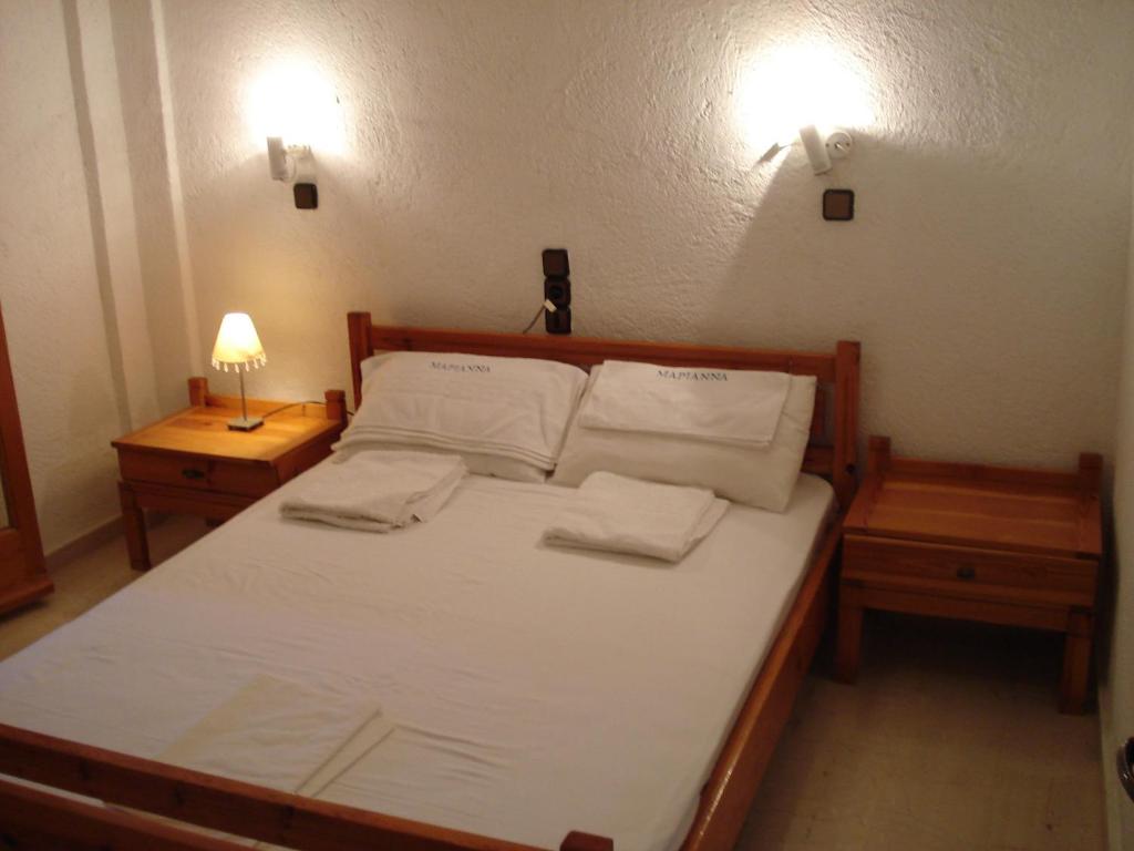 a bedroom with a bed with white sheets and pillows at Marianna Apartments in Agia Pelagia