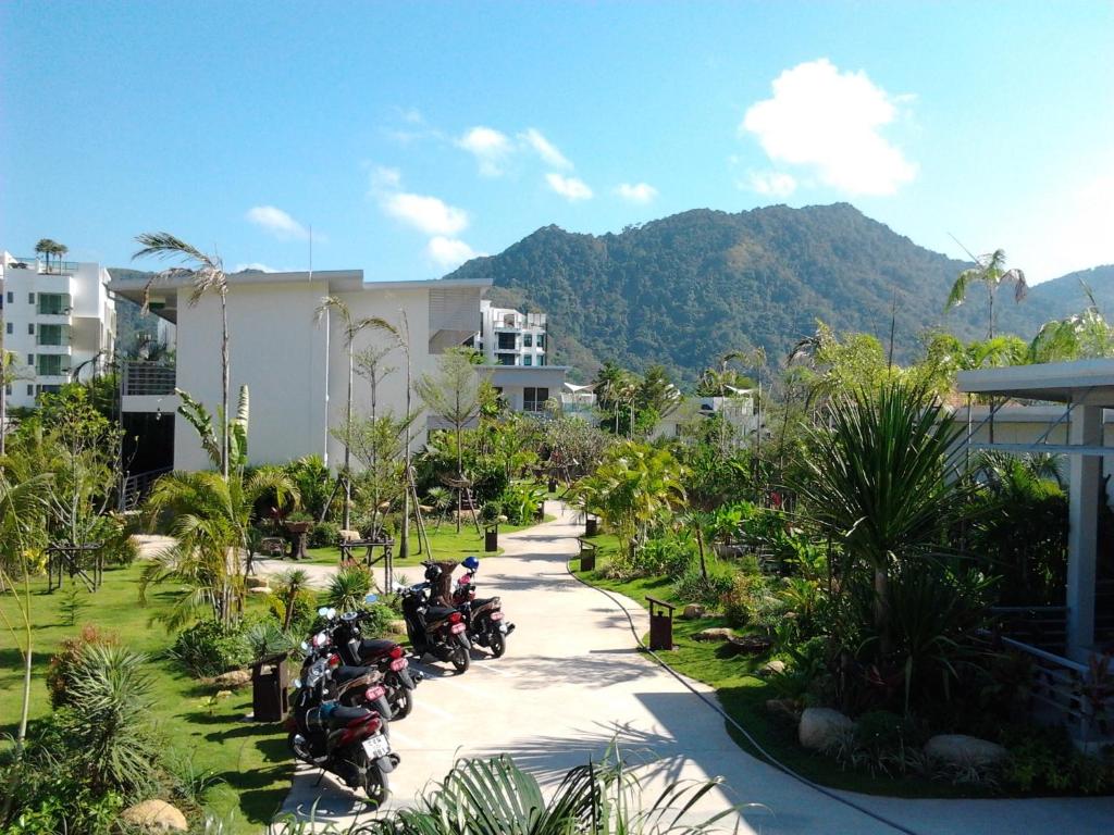 un grupo de motocicletas estacionadas frente a un edificio en Phukamala Suite, en Kamala Beach