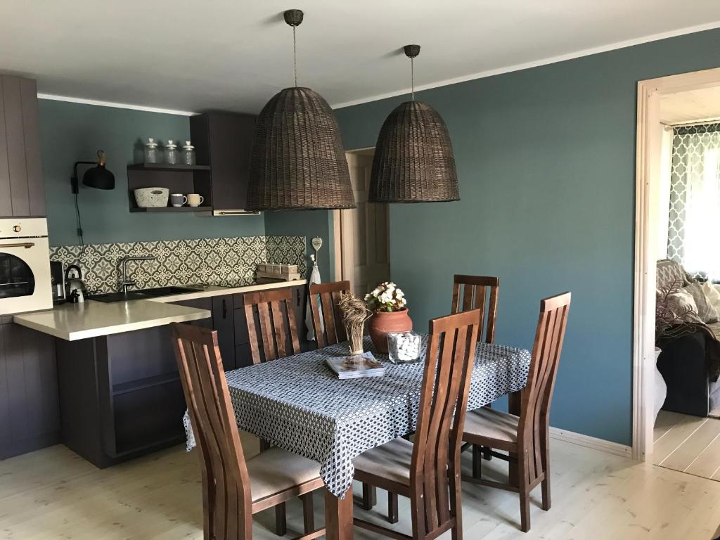 comedor con mesa, sillas y paredes azules en Apartment near by sea, en Jūrmala