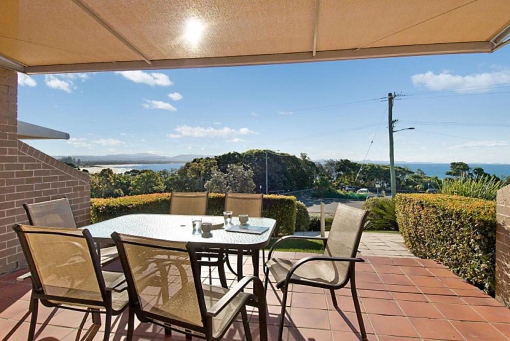 una mesa y sillas en un patio con vistas en Byron Bay Accom - James Cook Apartment 10, en Byron Bay