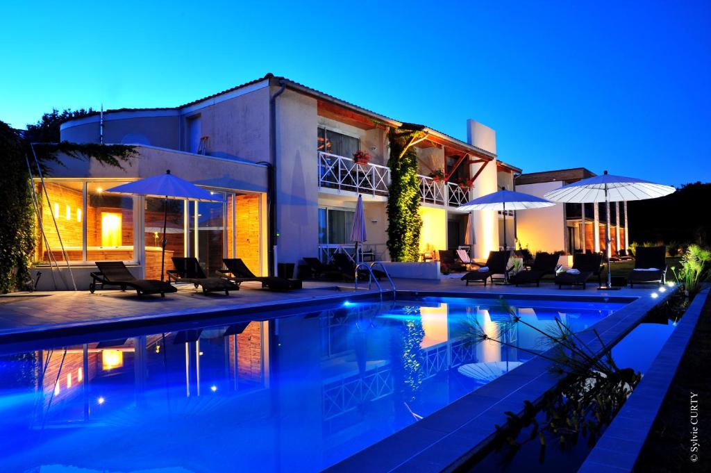 a villa with a swimming pool at night at Les Jardins du Lac in Trizay