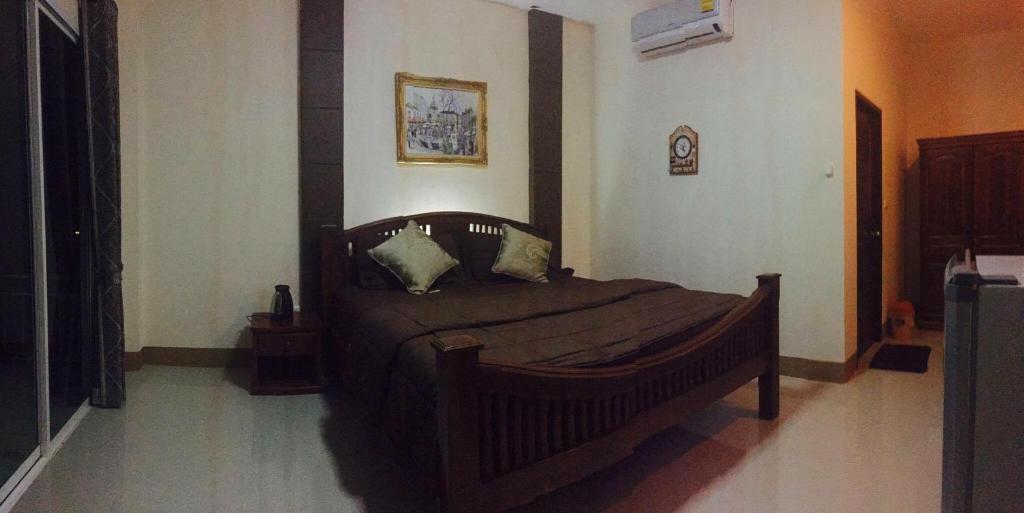 een slaapkamer met een houten bed in een kamer bij Tararin Resort in Ban Nong Nok Khian