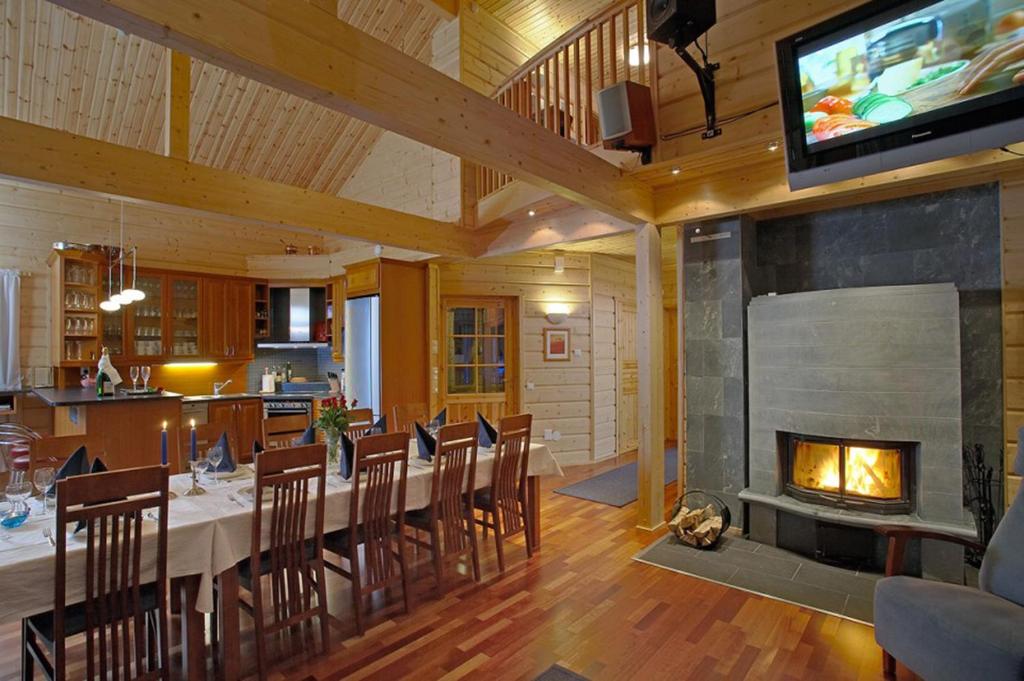 a dining room with a table and a fireplace at Levi President in Levi