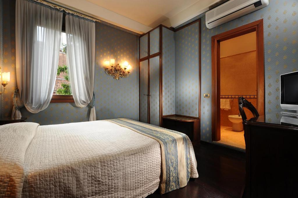 Postel nebo postele na pokoji v ubytování Hotel Abbazia