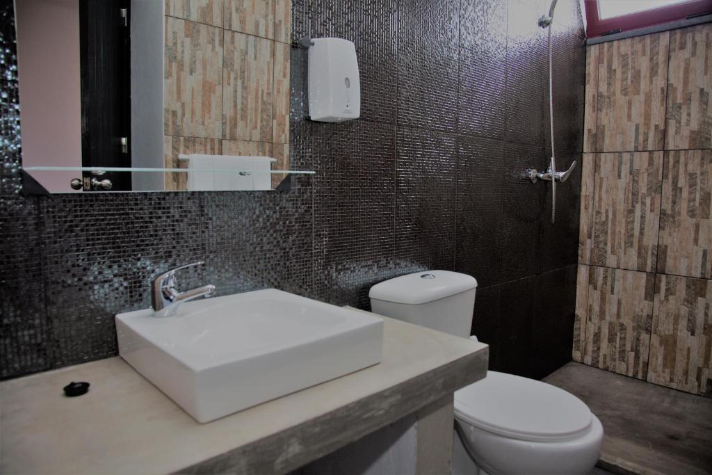 uma casa de banho com um lavatório branco e um WC. em Sara Village em São Roque do Pico