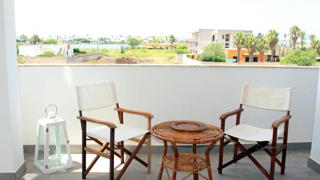ポルト・チェザーレオにあるSunkiss Apartment 500mt dal mareのテーブル、椅子2脚、窓付きテーブル
