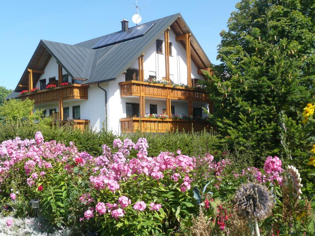 a house with a bunch of flowers in front of it at Hotel Bergblick in Warmensteinach