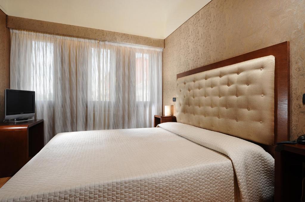 Postel nebo postele na pokoji v ubytování Hotel Abbazia