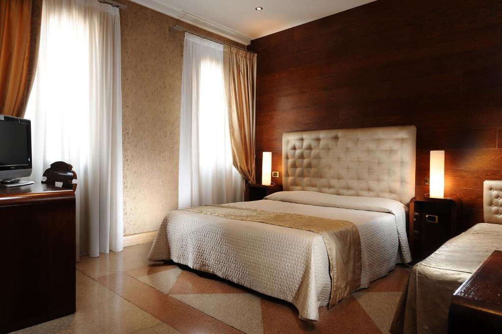 Postel nebo postele na pokoji v ubytování Hotel Abbazia