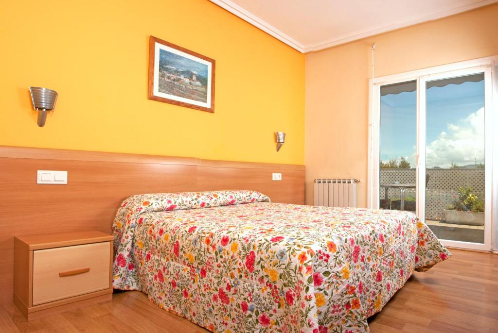 sypialnia z łóżkiem i oknem w obiekcie HOSTAL EUROPA pensión w mieście Irún