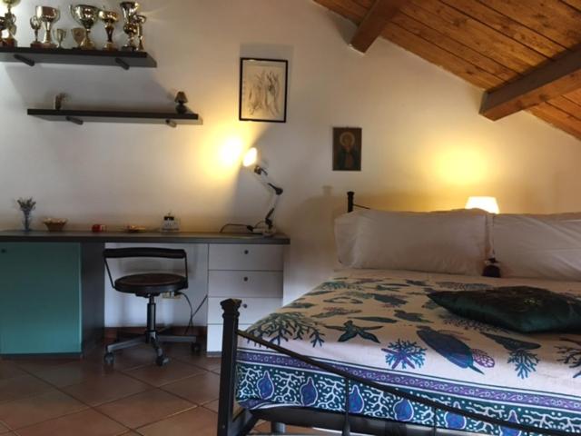 a bedroom with a bed and a desk and a chair at L'Oasi in Genoa