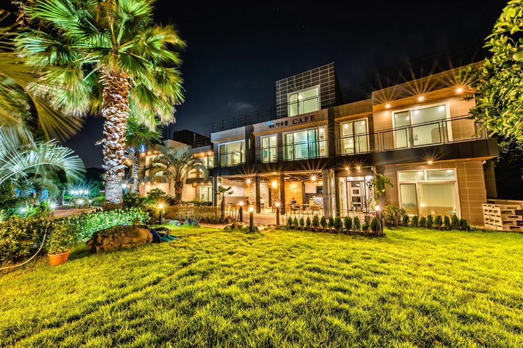 a house with a palm tree in front of it at Jeju Aurum in Seogwipo