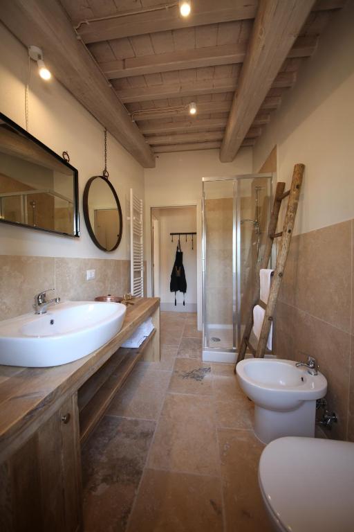 łazienka z umywalką, toaletą i lustrem w obiekcie Collitorti Original Design Apartment w mieście Chianciano Terme