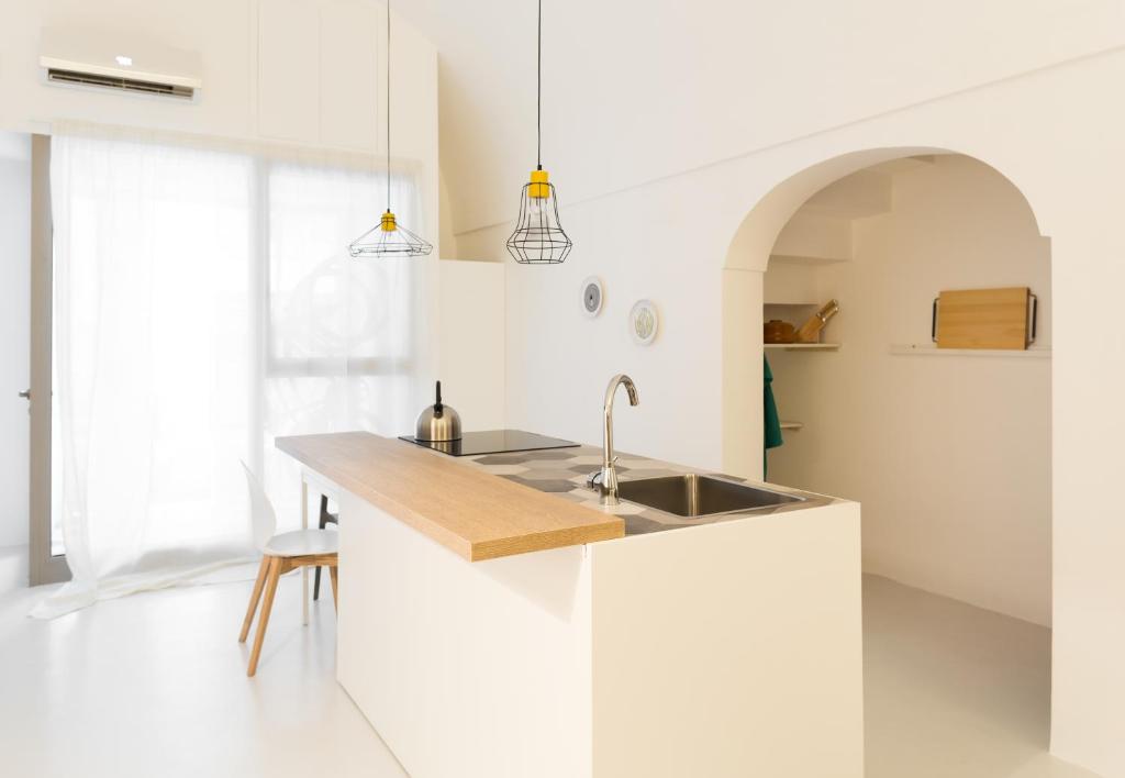 una cucina bianca con lavandino e bancone di B22 - COMFY BEAUTIFUL LOFT a Monopoli