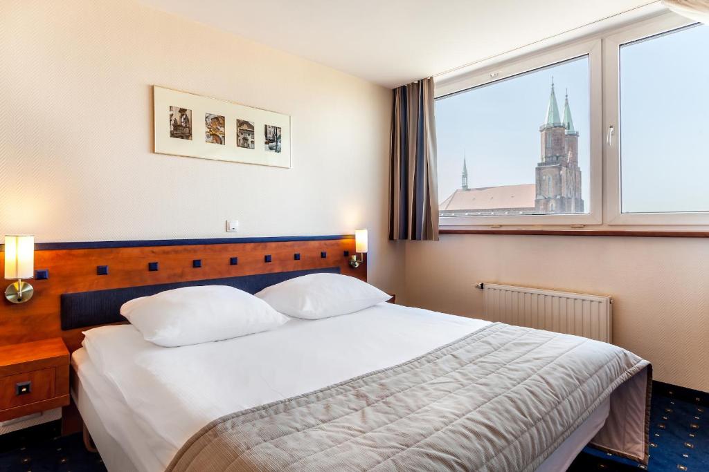 En eller flere senge i et værelse på Qubus Hotel Legnica
