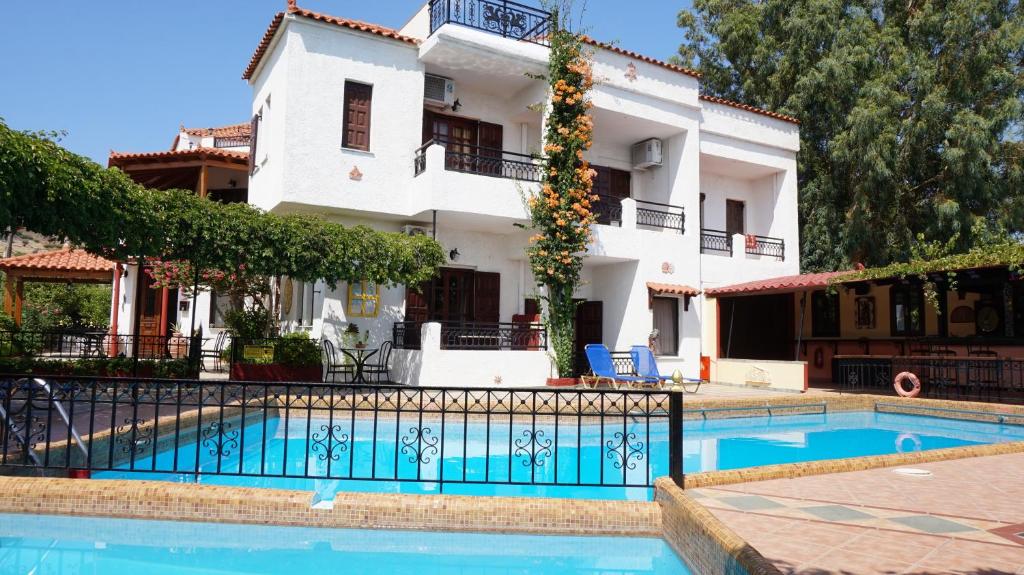 a villa with a swimming pool in front of a building at Hotel Mary in Marathokampos