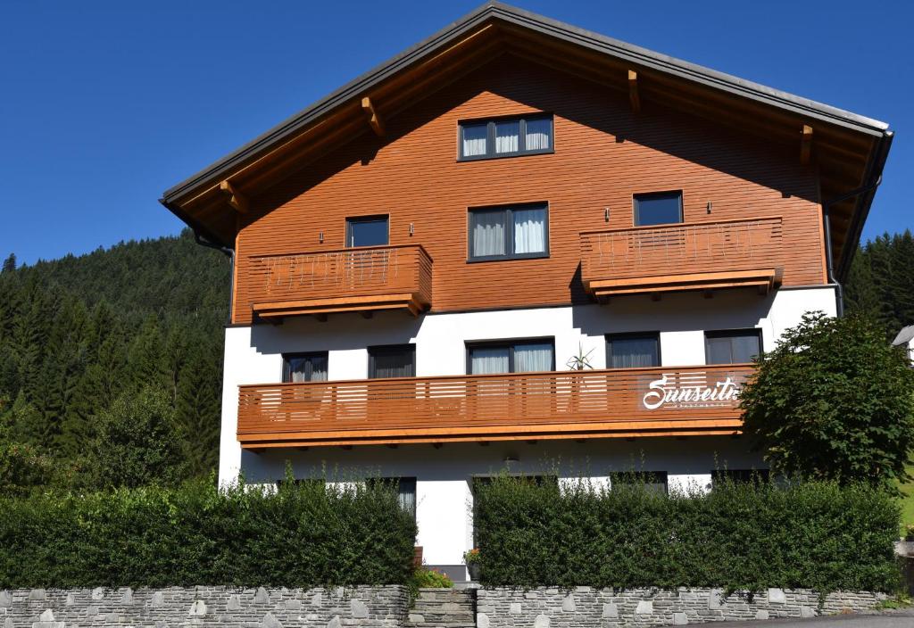 a large wooden building with a balcony at Sunseitn Apartments in Gosau