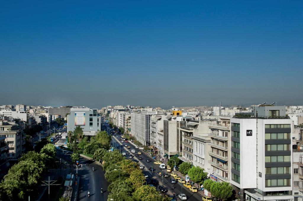 een uitzicht op een stad met auto's en gebouwen bij NLH FIX | Neighborhood Lifestyle Hotels in Athene