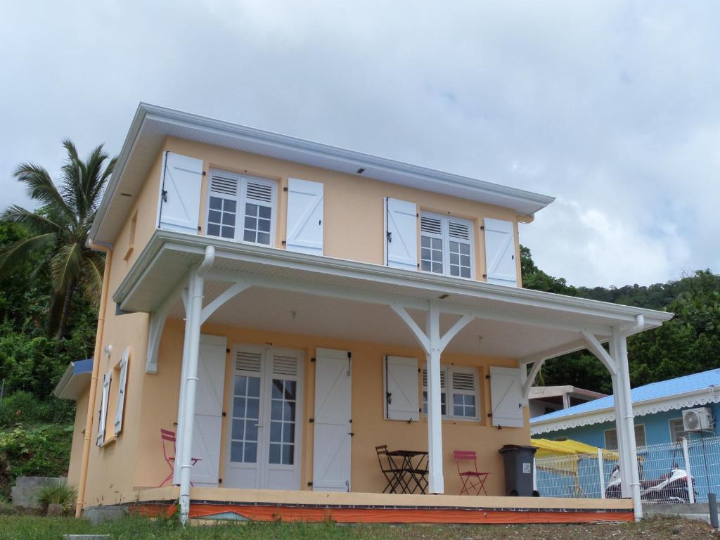 une maison avec des fenêtres blanches et un toit dans l'établissement Les Hauts des Anses, à Les Anses-d'Arlet