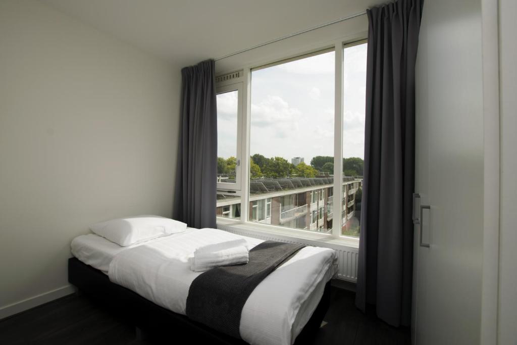 アムステルダムにあるホワイト ムーン アパートメントのベッドルーム1室(ベッド1台、大きな窓付)