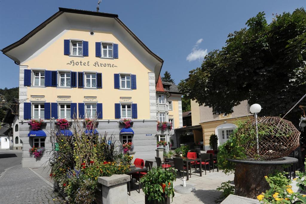 a white building with flowers in front of it at Hotel Krone in Schruns