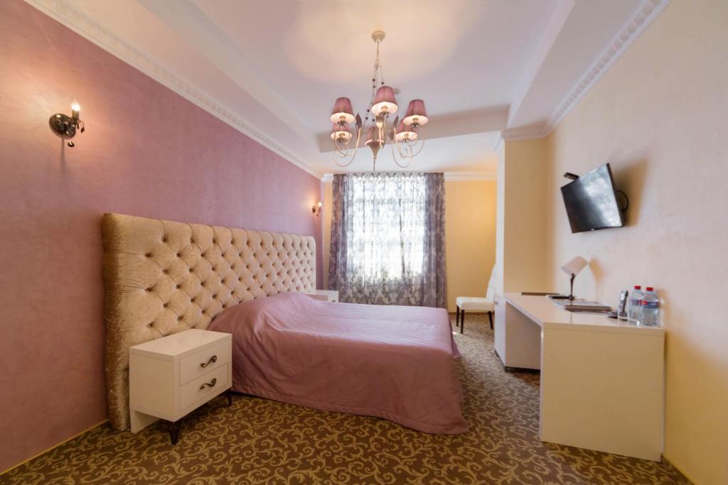 een slaapkamer met een bed en een kroonluchter bij Hotel Onegin in Stavropol