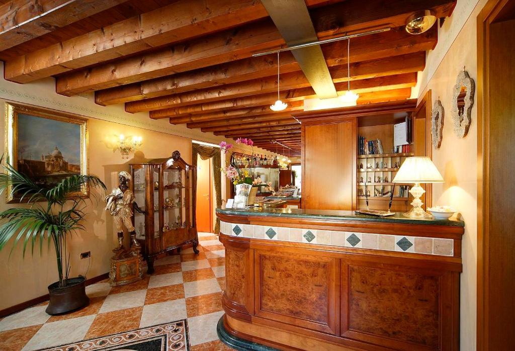 un ristorante con bar in una stanza con pavimento a scacchi di Hotel Antico Moro a Zelarino