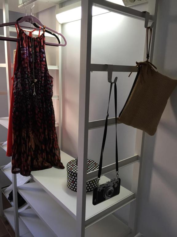 a shelf with a camera and a dress on it at Casa Campillo, Habitaciones Individuales in Telde