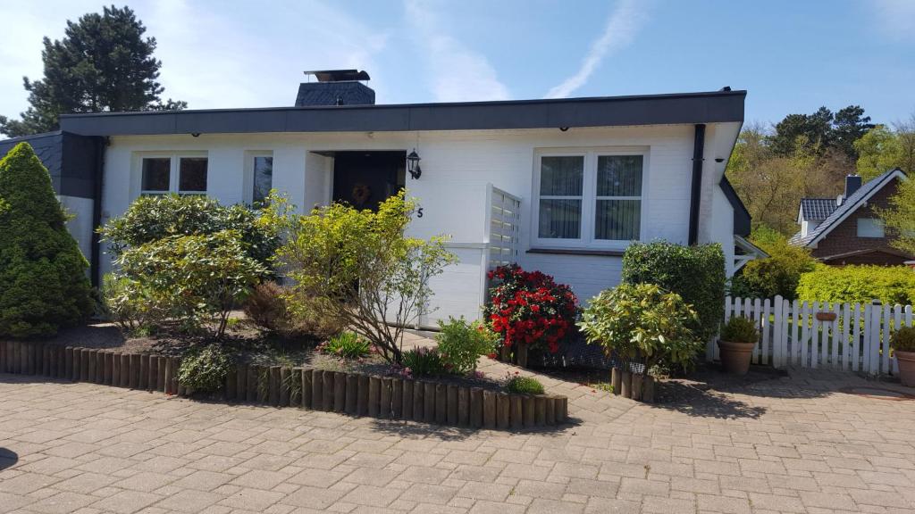 een wit huis met een hek ervoor bij Ferienwohnung Weiser in Cuxhaven