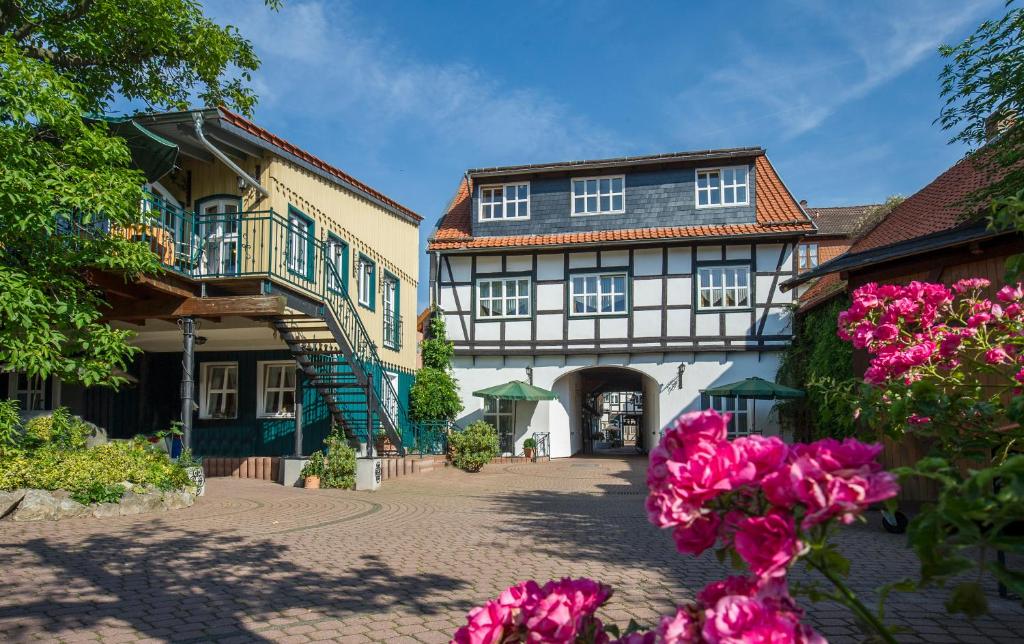 un edificio con flores rosas delante de él en Am Anger, en Wernigerode