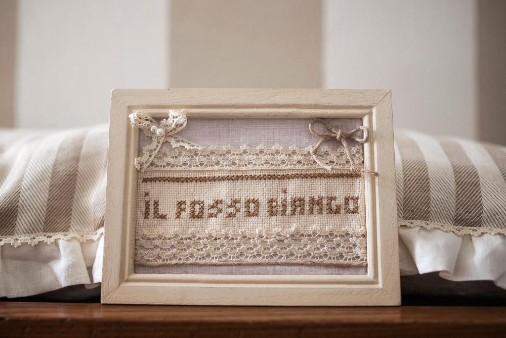 a picture frame sitting on a table next to a bed at B&B Il Fosso Bianco in Bagni San Filippo