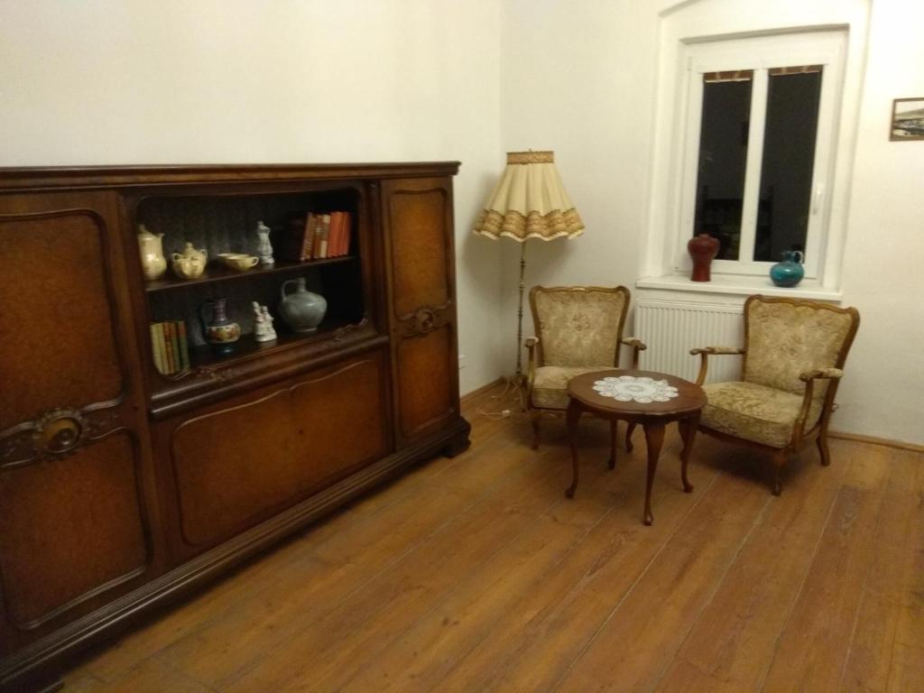 オストロフにあるPenzion u Čermákaのリビングルーム(キャビネット、椅子2脚、テーブル付)