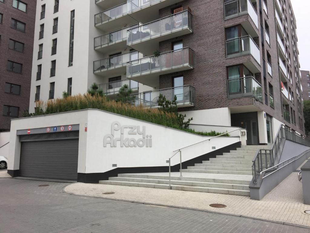 an apartment building with stairs and a garage at Apartamenty przy Arkadii in Warsaw