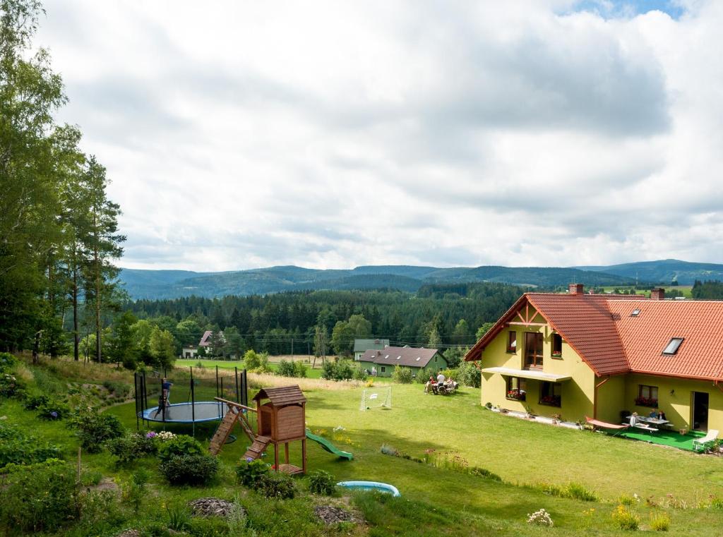 a house in a field with a playground at Apartamenty w Gorach Stolowych in Szczytna