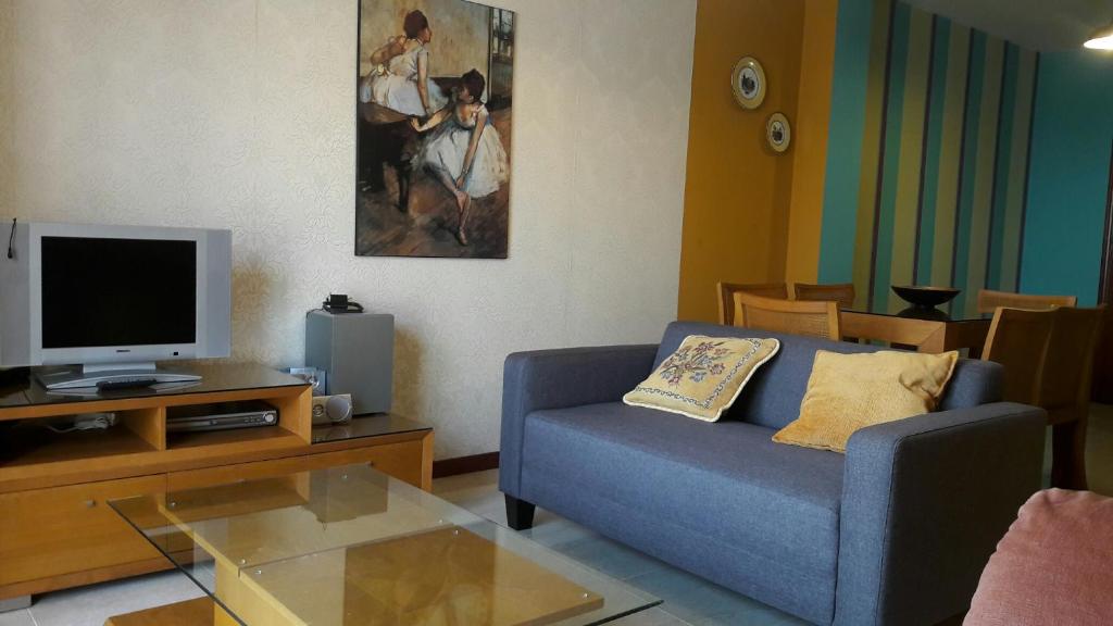 ビラノーバ・デ・アロウサにあるPiso Sinasのリビングルーム(青いソファ、テレビ付)