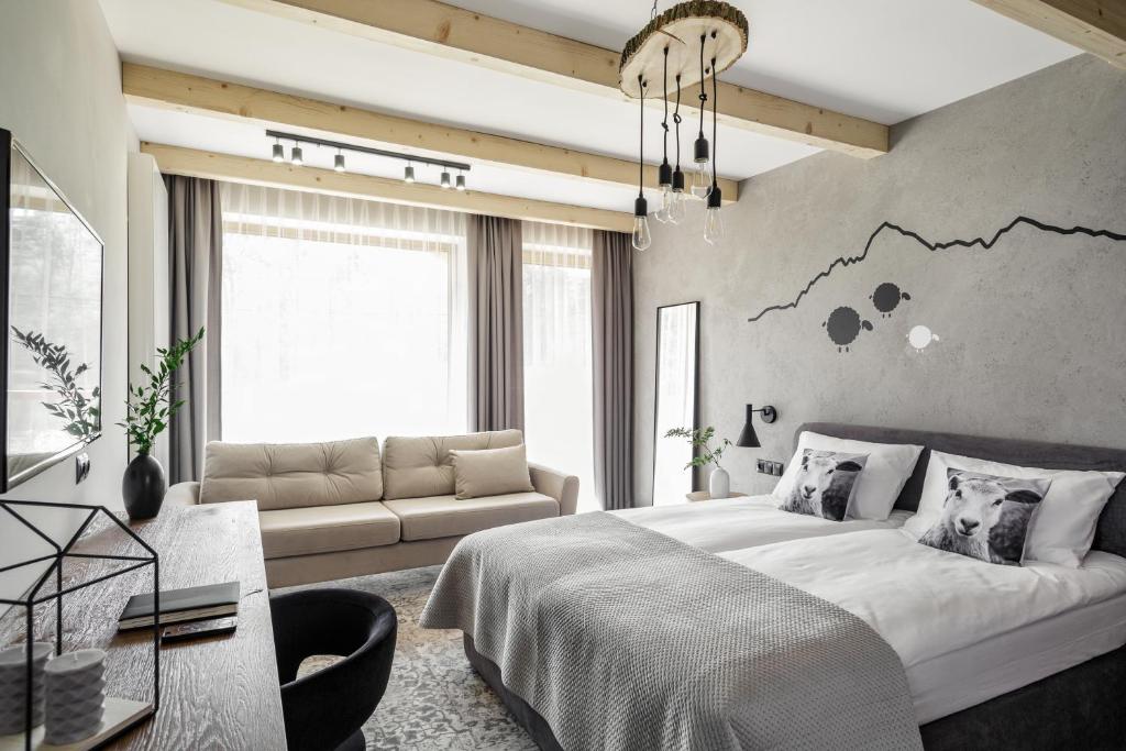 una camera con un grande letto e un divano di Biała Owca a Zakopane