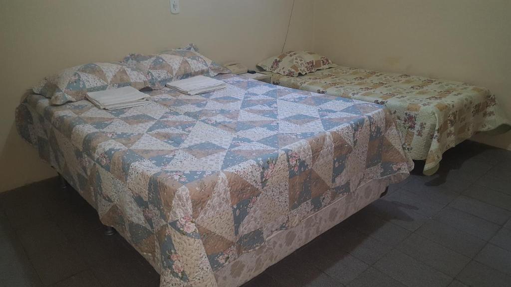 a bedroom with a bed with a quilt on it at Pousada Portal do Cariri in Juazeiro do Norte