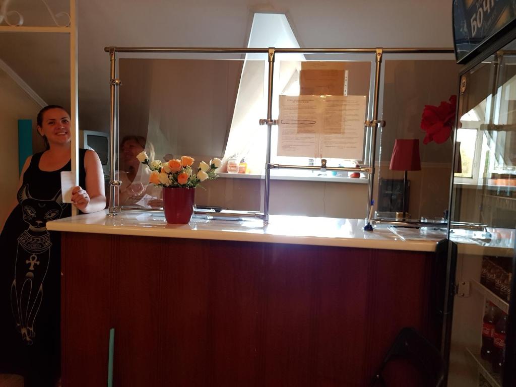 ソルネチノゴルスクにあるMini-hotel Na Turgenevskoi 8Bの花瓶を持つカウンターの後ろに立つ男