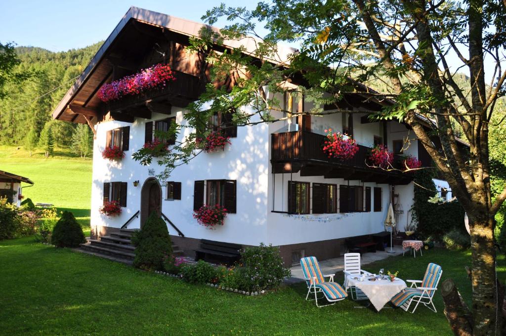 ein weißes Haus mit einem Tisch und Stühlen im Hof in der Unterkunft Haus Thurner in Obsteig