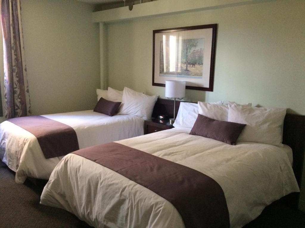 a hotel room with two beds in a room at Auberge Centre Ville in Saguenay