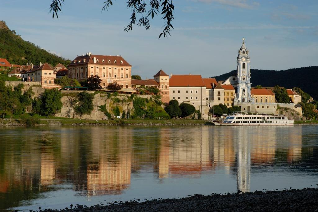 a large building on the shore of a body of water at Hotel Schloss Dürnstein in Dürnstein