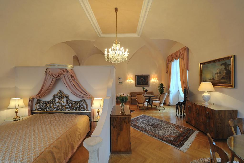 a bedroom with a large bed and a dining room at Hotel Schloss Dürnstein in Dürnstein