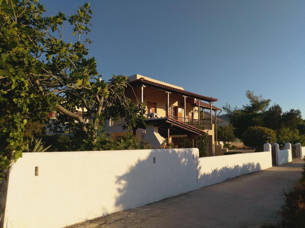 ein Haus hinter einem weißen Zaun in der Unterkunft Explore Aegina Island in Souvala