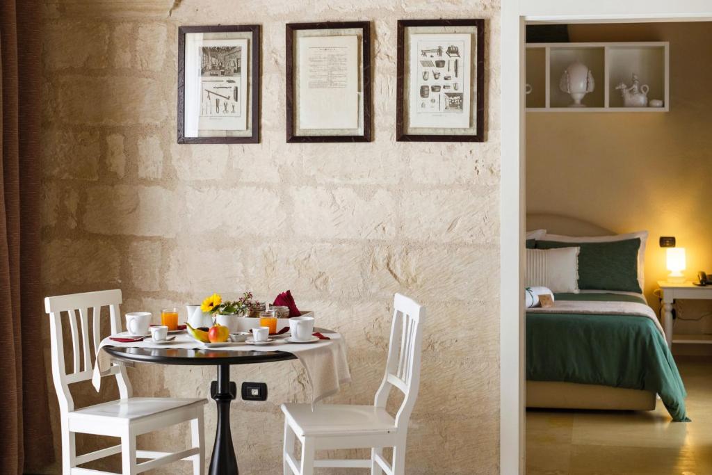 a dining room with a table and chairs and a bed at Corte Dei Francesi in Maglie