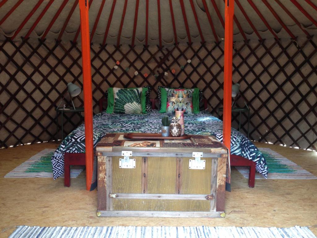 a bed in a yurt with a wooden table at Finca Fahala in Cártama