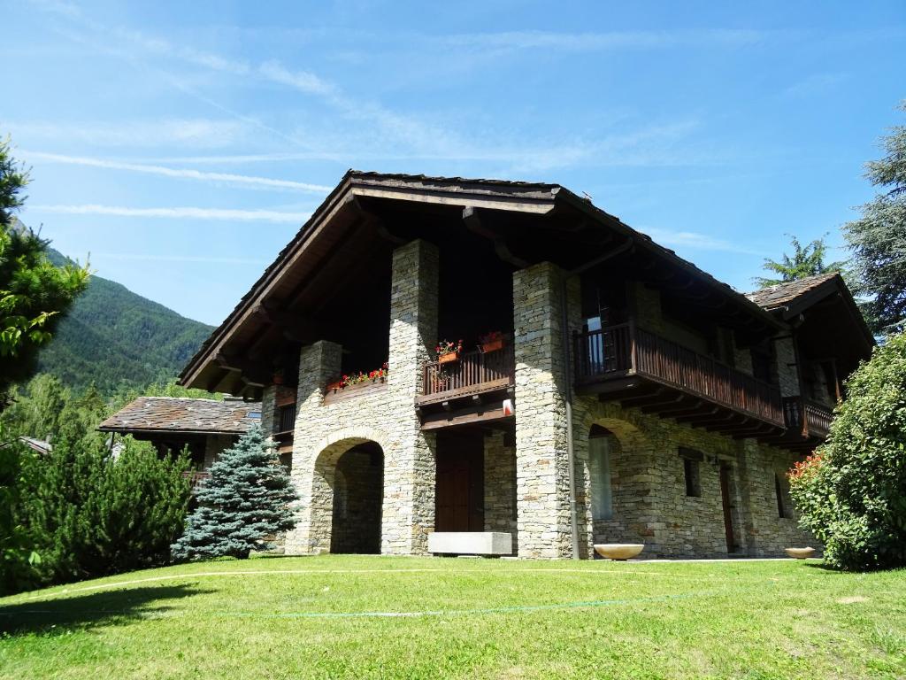 a large house with a balcony on a lawn at La Rouine - Morgex in Morgex