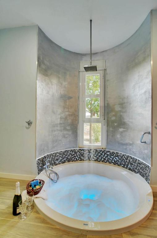 a large tub in a bathroom with a window at AlmenaraLove Bellaluna in Robledo de Chavela