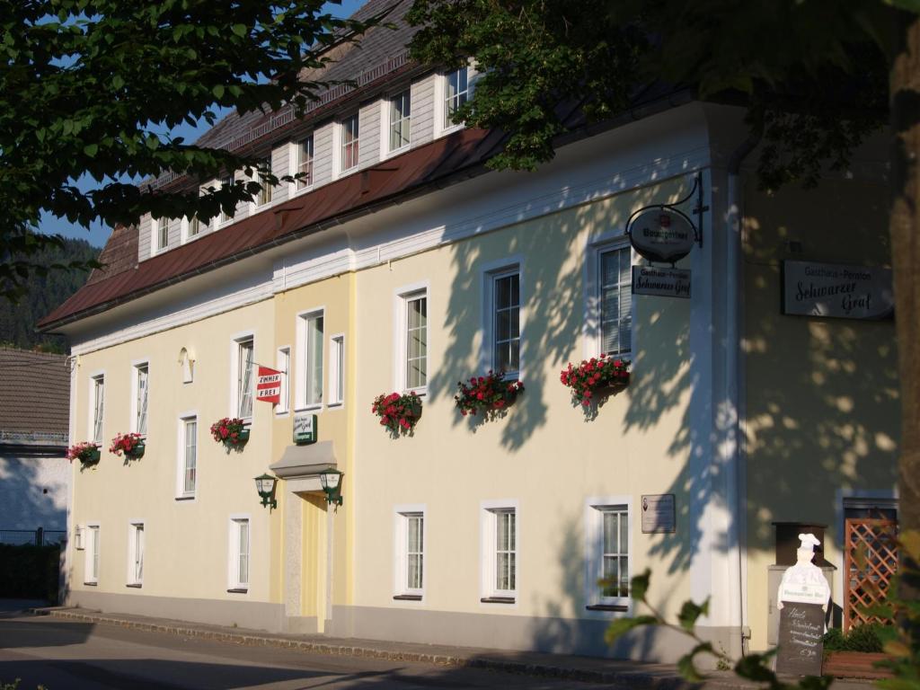 un edificio blanco con flores a un lado en Gasthaus-Pension Schwarzer Graf, en Windischgarsten