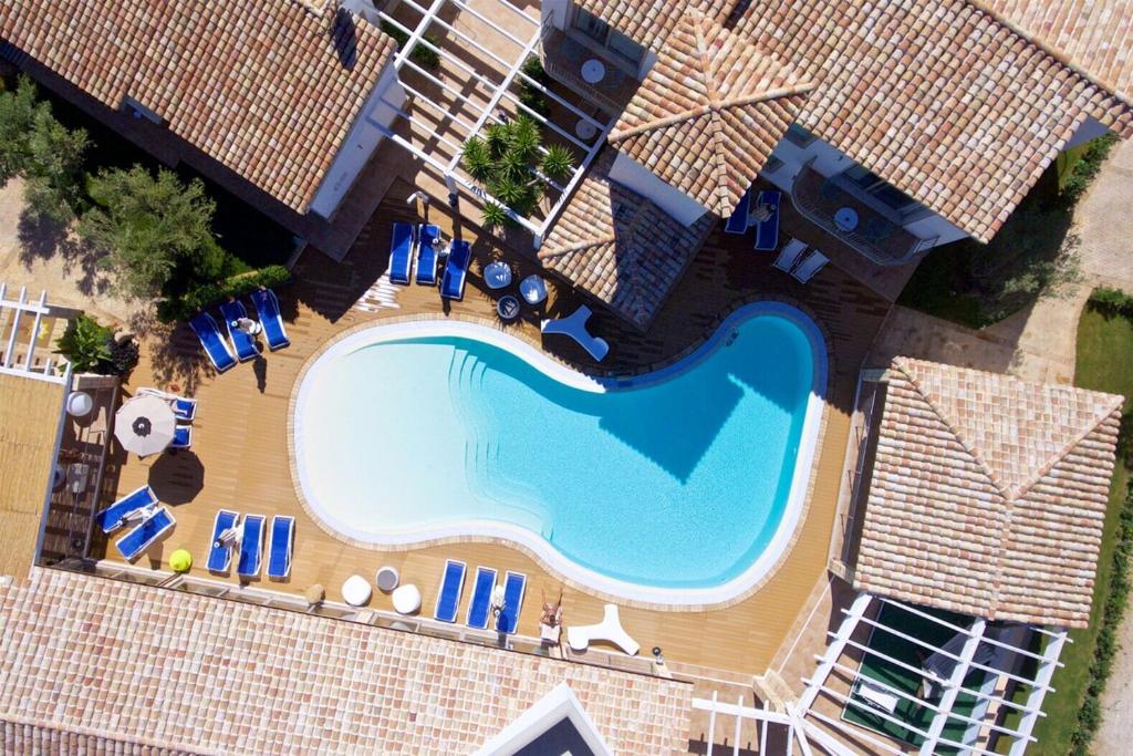 una vista sul soffitto di una piscina con sedie e ombrelloni di Eliantos Boutique Hotel & Spa a Santa Margherita di Pula